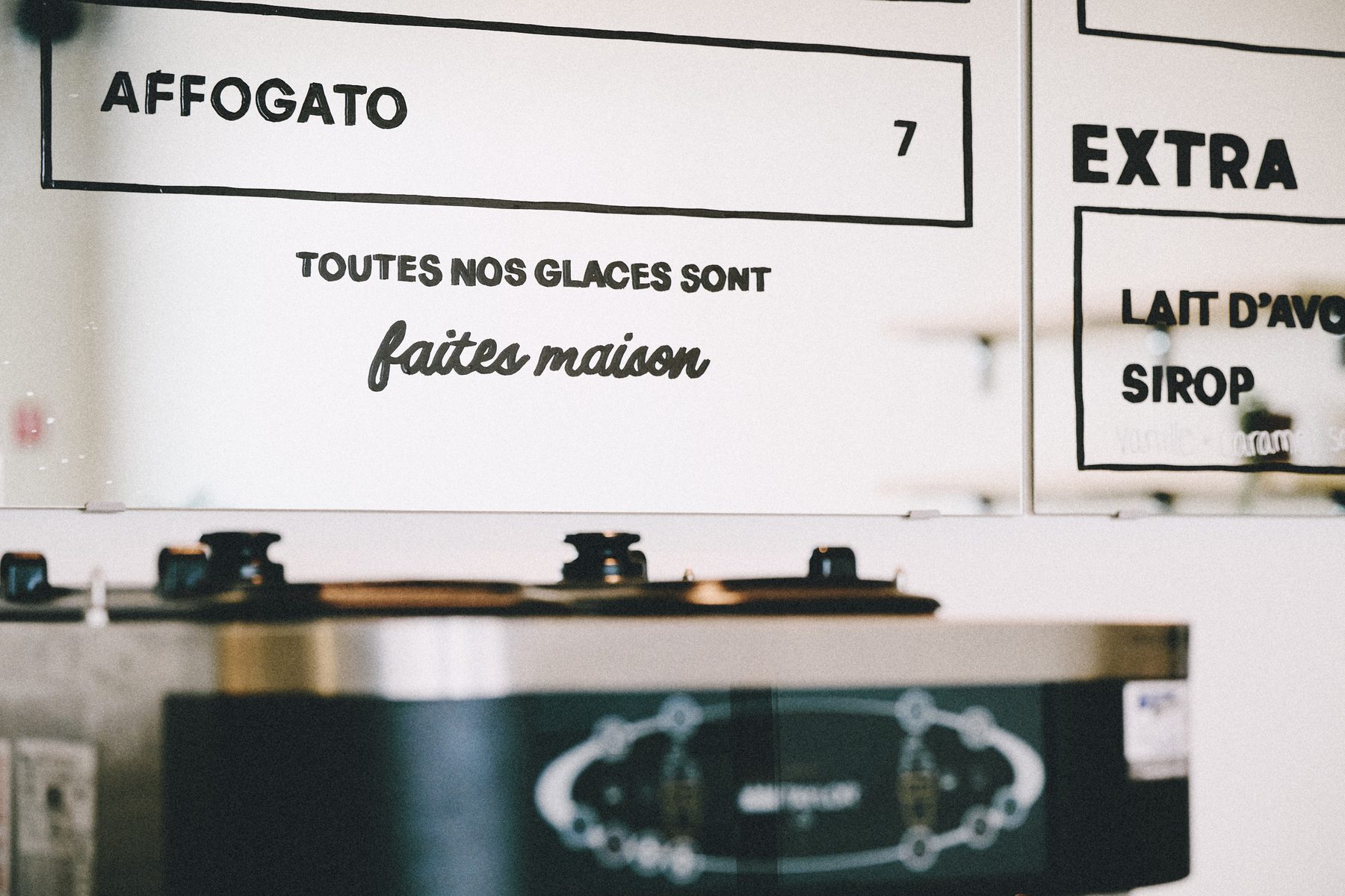 Hand-lettered Mauka menu on mirrored panels above the counter