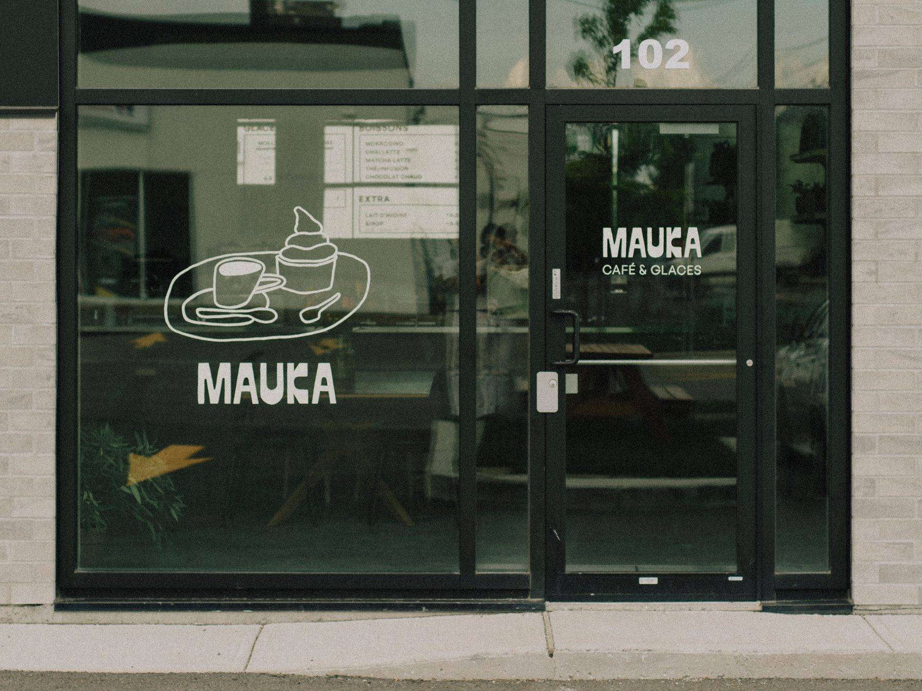 Mauka Café & Glaces storefront with hand-painted window graphics and door lettering
